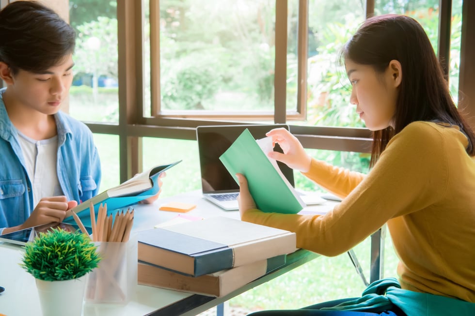 Students Reading Books at the Library for Research Project